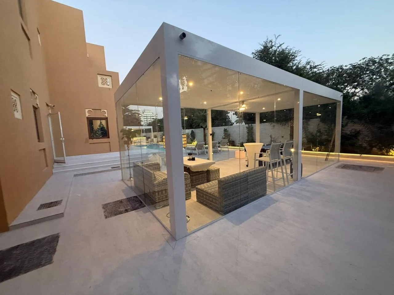 Glass-enclosed aluminium pergola beside a villa pool in Dubai
