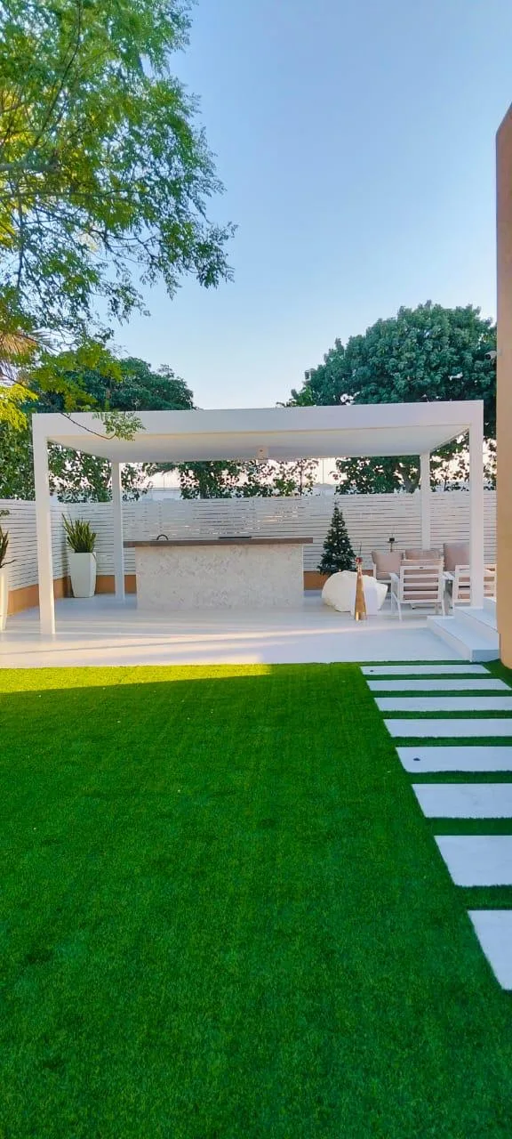 Aluminium pergola with outdoor bar and green lawn in a Dubai garden